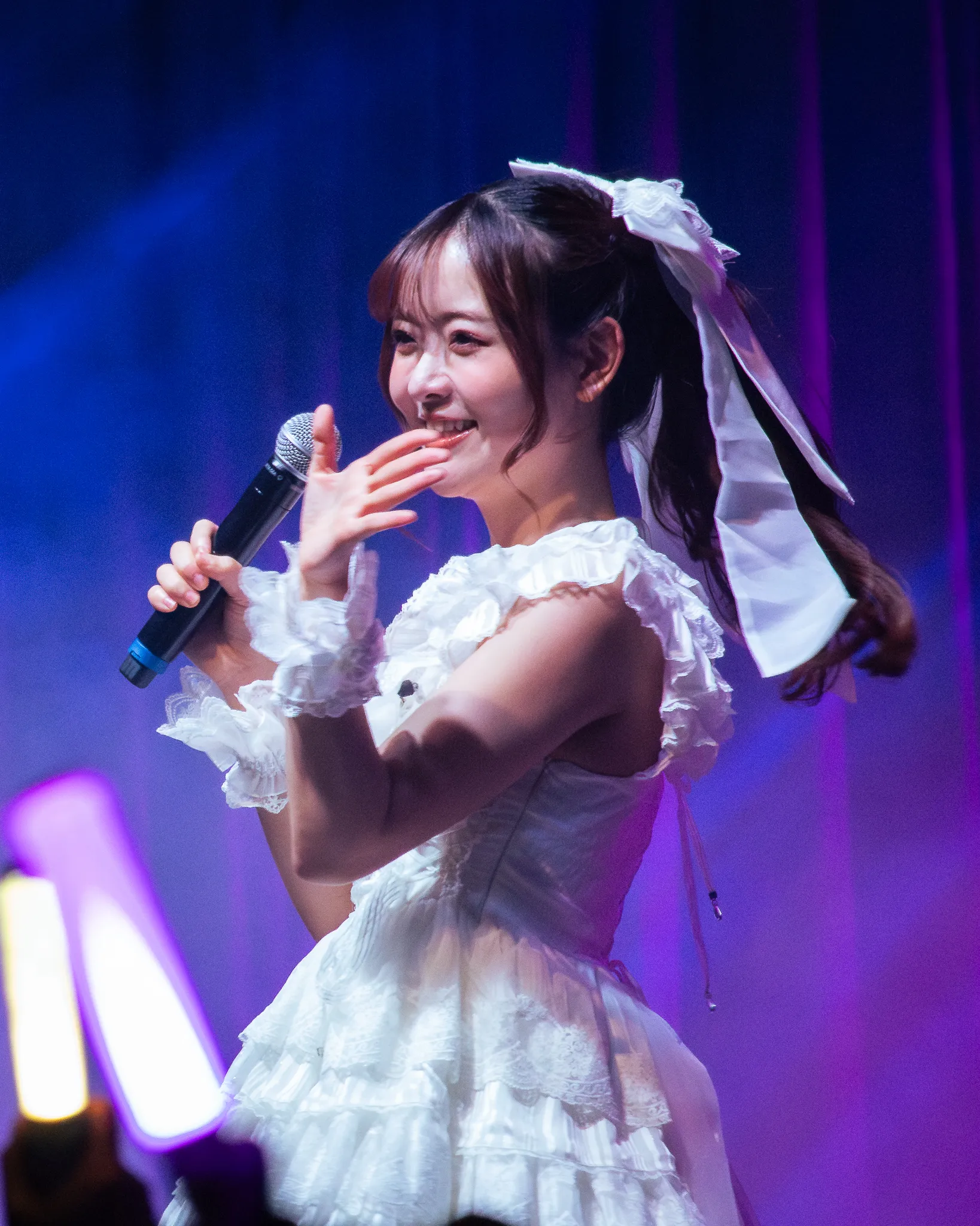 Sally Amaki, an American voice actress and singer for the music group 22/7 perfmoning on stage.