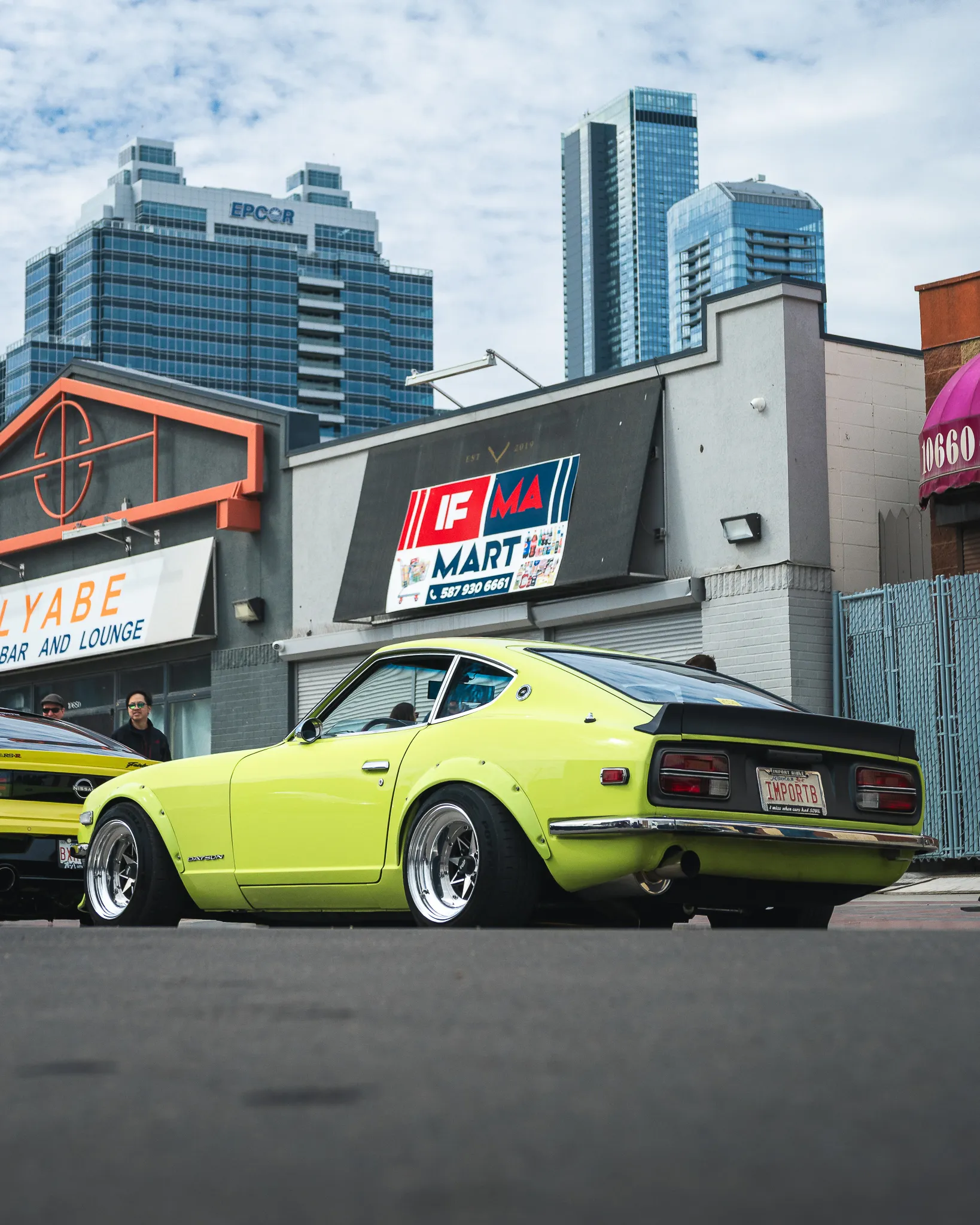 A low shot of a lime green datsun 240z parked.